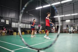 Badminton players competing on an indoor court
